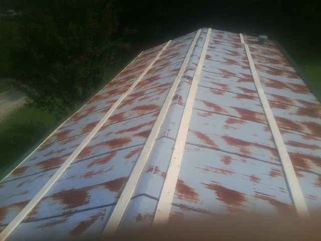 Rusted metal roof panels with new wood purlins before replacement — Storm Damage Roof Repair in Goldsboro by Roofing Brothers